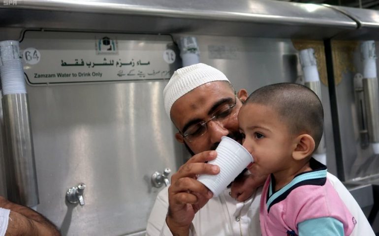 طفل يشرب كوب من ماء زمزم